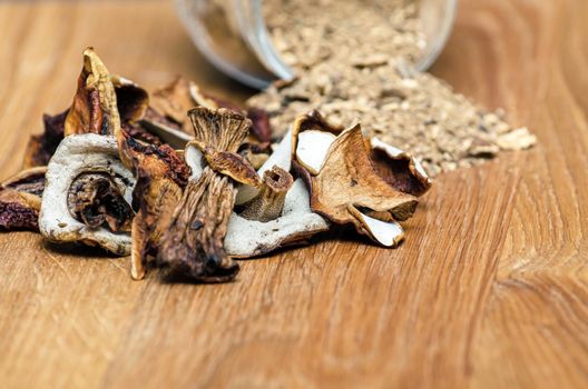 dried mushrooms on spread out on a wooden table. Chopped boletus in a container. Copy space