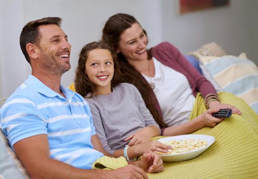 Enjoying a family comedy. a family watching a movie on the sofa