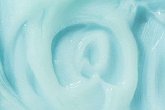 Blue cream, moisturizer, shampoo spread, sunscreen cosmetic smear background. Moisturizing beauty creme, balm swatch, paint texture. Creamy fluid skincare lotion mousse product closeup.