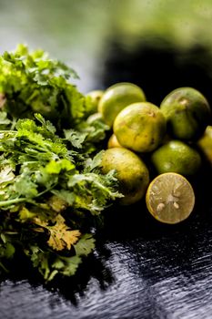 Face mask for blackhead and dry skin on a surface consisting of some coriander leaves and fresh lemon juice. Shot of fresh parsley leaves and lemons for blackhead removal face mask.