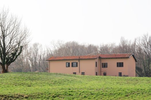 House on green meadow field hill in late spring. Como, Italy