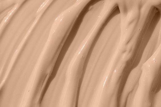 Cosmetic tonal moisturizer, bb cream swatch sample. Beige nude liquid foundation texture, concealer smear smudge drop. Make up base, cream textured background. Closeup macro