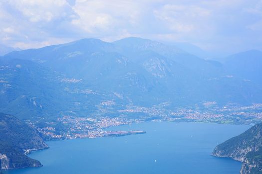 Aerial view of mountain lake Iseo, forested mountains, various villages scattered along the slopes and along the coast. Located in Brescia province, Lombardy, Italy. Picturesque summer landscape.