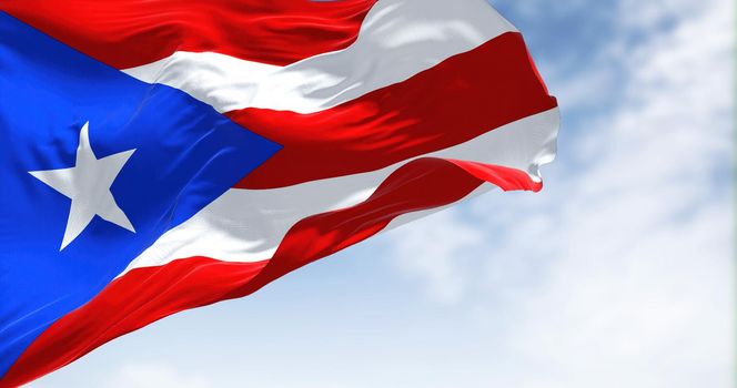 Flag of Puerto Rico waving in the wind on a clear day. Puerto Rico is a Caribbean island and unincorporated territory of the United States