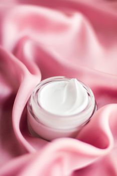 Beauty, anti-age cosmetics and skincare concept - Luxury face cream jar on a soft pink silk