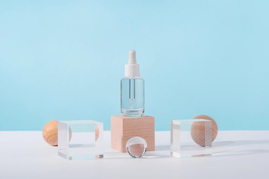 Serum cosmetic bottle with peptides and retinol on acrylic and wooden blocks on pink background. Oil cosmetics transparent product packaging with stylish props. Serum dropper mockup on pedestal podium