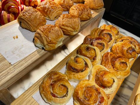 Lines of fresh baked cinamon rolls, super delicious cinamon rolls, French and American Croissants and baked cinamon rolls are enjoyed world wide on bakery shop, tasty multiple baked cinamon rolls