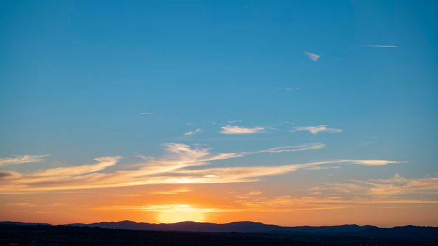 Majestic sunset in the mountains landscape. Big sun hiding behind the mountains in Madrid, Spain. Copy space.