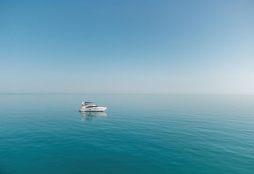 Aerial boat race. Luxury cruise trip. View from above of white boat on deep blue water. Aerial view of rich yacht sailing sea. Motor boat racing wave. Summer journey on luxury ship