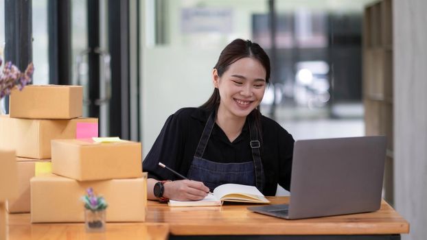 Female entrepreneurs Small Business SME Independent work at home, using laptops for commercial checking, online marketing, packing boxes, SME sellers concept, online sales..
