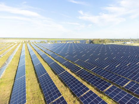 Aerial top view of a solar panels power plant. Photovoltaic solar panels at sunrise and sunset in countryside from above. Modern technology, climate care, earth saving, renewable energy concept