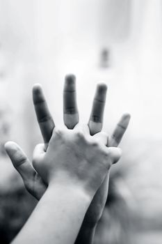 Child hand comparing her hand with her father shot with blurred bokeh background and the concept of Father’s day ( 16th June).