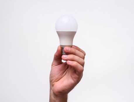 man hold Led lamp in hand. Eco lamp, green technologies. Energy efficiency concept. on a white background