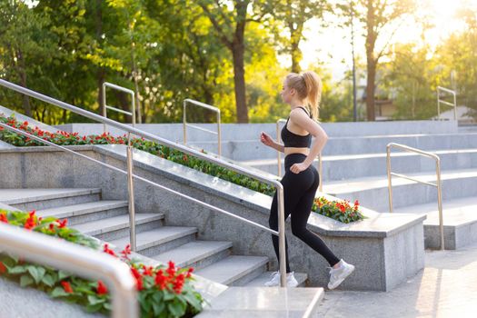 Sport and Fitness. Fit Woman Running up stairs Summer Sunny Morning Caucasian Athletic Female Jogging Outdoor Cardio Training Active Healthy Lifestyle Dressed Black Sportswear Motivation Concept