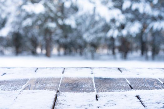 Beautiful winter scene. blurred background of snowy christmas nature background, Wood table top on shiny bokeh. For product display Christmas time mock up