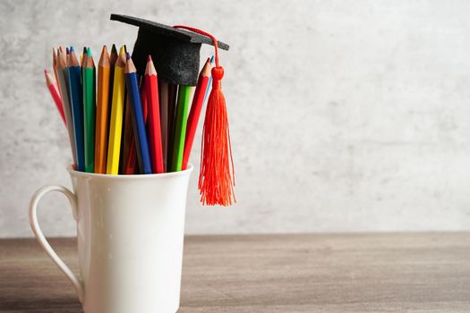 Graduation hat with colorful pencils on book with copy space, learning university education concept.