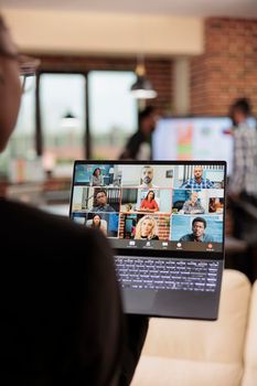 Woman attending business meeting videocall with colleagues, talking on online videoconference call with webcam. Using laptop to talk on remote teleconference chat, telecommunications.