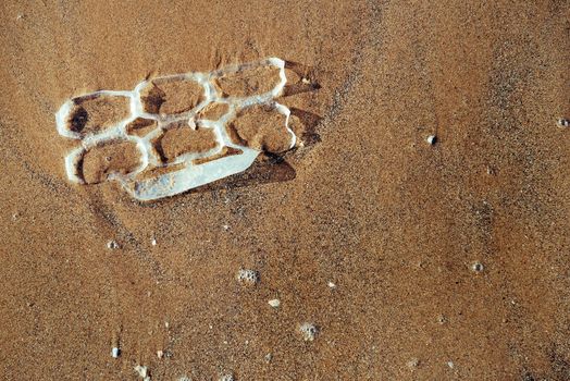 background of a plastic rings lying on the sand of the beach polluting the sea and the marine life, concept of pollution control of the oceans by plastic, copy space for text