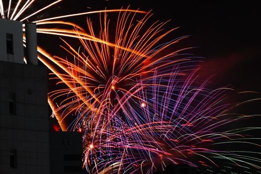 Fireworks seen from between the narrow of buildings. Shooting Location: Tokyo metropolitan area