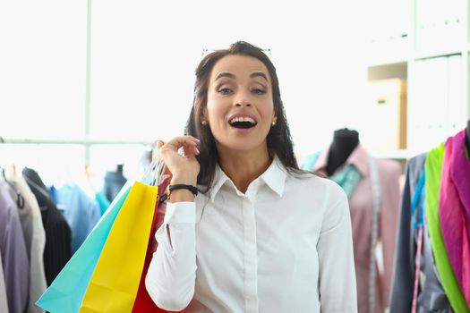 Joyful shopping woman holding shopping bags. Beautiful happy shopper with shopping packages