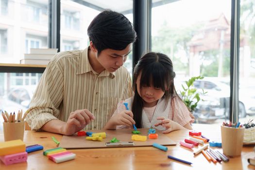 Adorable little girl and father playing with colorful plasticine. Handmade skills training.