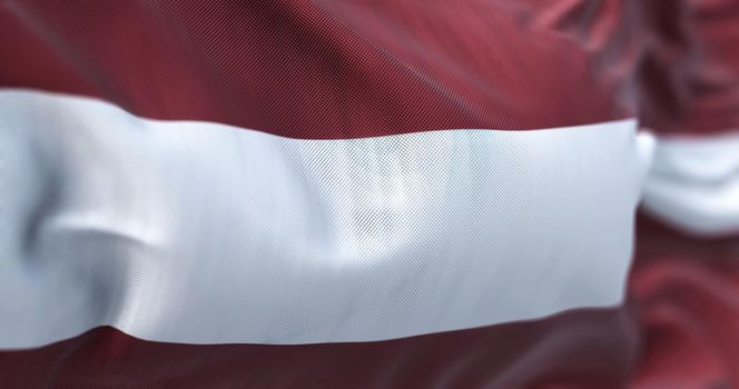 Close-up view of the latvian national flag waving in the wind. The Republic of Latvia is a country in the Baltic region of Northern Europe. Fabric textured background. Selective focus