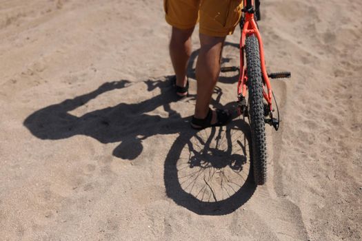 Rear wheel of mountain bike and rider leg. Rear shot of mountain bike on dirt road and closeup of mountain bike tire