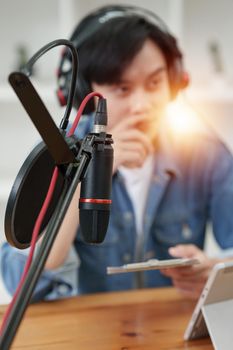 Podcaster making audio podcast working with guest at home studio.