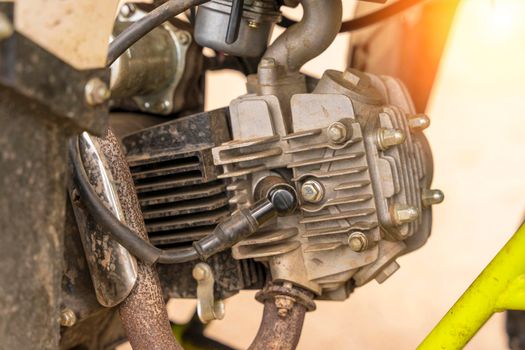 single-cylinder ATV engine close-up. spark plug, aluminum cylinder and block head, muffler intake pipe. the engine of the moped in close-up. vertical photo