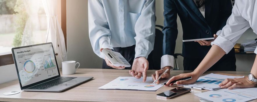 Closeup of businesspeople hands pointing a pie chart together on the paperwork.