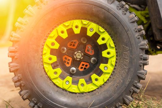Close-up of the ATV wheel on sandy ground. Dirty wheel of a four-wheel drive all-terrain vehicle. The concept of travel and adventure