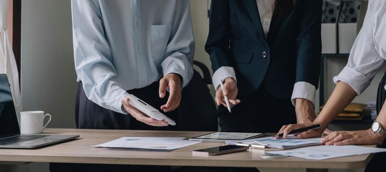 Asian business people meeting with new startup project pointing graph discussion and analysis data charts and graphs.Business finances and accounting concept.