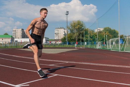Young woman running on the running track at the stadium outdoors