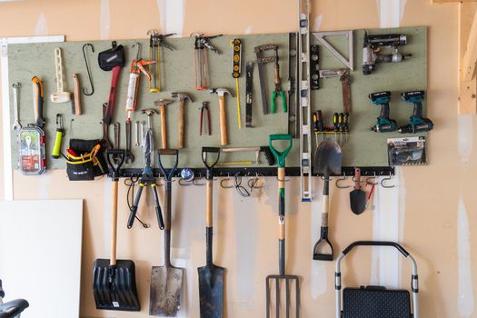 Board on garage wall with attached tools