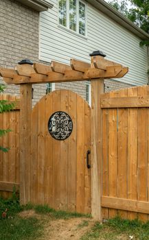 Wooden door with a round window at the entrance to the courtyard of a private house