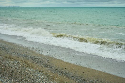 Seascape, shore with pebbles, wet sea pebbles on the beach and quiet sea surf