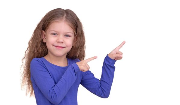 Smiling and happy child kid showing by index fingers on two hands on copy space isolated on white background looking at camera waist up caucasian little girl of 5 years in blue