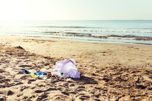 plastic bag of a volunteer to collect waste washed up by the sea, people helping to keep nature clean and picking up the garbage from shore, campaign to clean on the beach, copy space for text