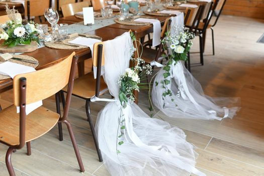 Wedding chairs decorated with white cloth and flowers