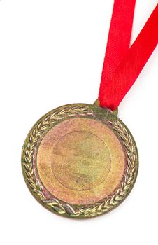 Gold medal with a red tape isolated on white.