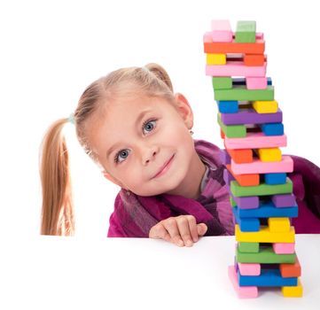 little girl playing with the wood game jenga on white background