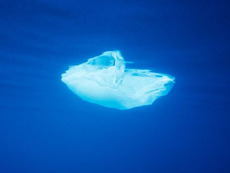 plastic waste at the ocean, a plastic bag in the Mediterranean sea floating at the blue water surface view from underwater, environmental problem with plastics pollution