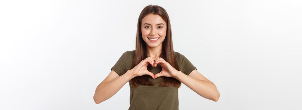 Smiling teenager girl making heart shape with her hands isolated on white
