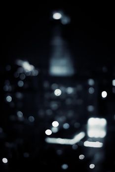 Big metropolitan city lights at night, blurry background - night life, abstract background and modern dark tones concept