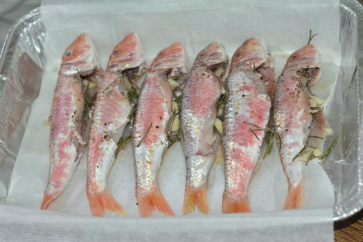 Preparation mullet with rosemary and garlic for baking in the oven