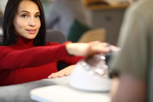 Portrait of woman doing a manicure in beauty salon. Nail and hand skin care and manicure services