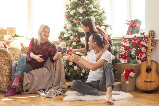 Christmas family. Happy mom, dad and little daughter. Enjoyng love hugs, holidays people. Togetherness concept.