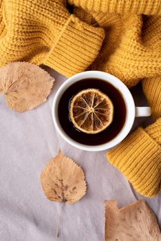 Hello fall. Cozy warm image. Cozy autumn composition, sweater weather. Pumpkins, hot tea with lemon and sweaters on window