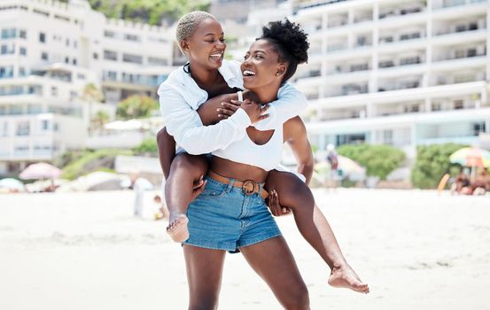 Lesbian, gay and lgbt woman couple having fun with a smile together on the beach during summer. Dating, romance and love with a homosexual female and her partner on holiday or vacation.