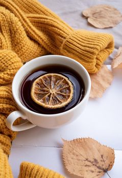 Hello fall. Cozy warm image. Cozy autumn composition, sweater weather. Pumpkins, hot tea with lemon and sweaters on window